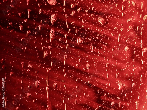 Wasser rinnt an roter Scheibe
