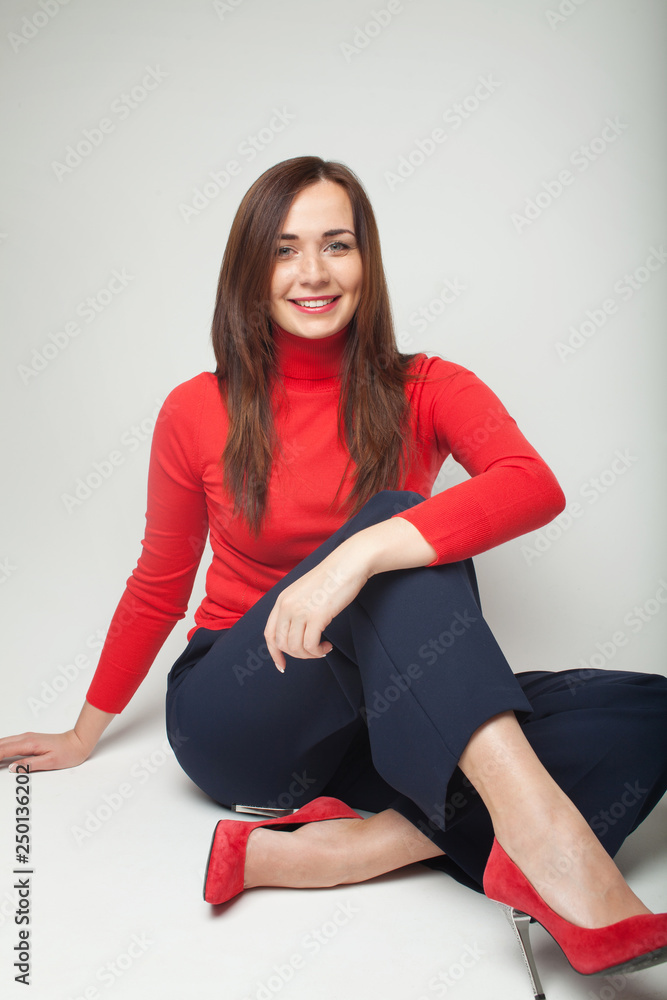 Foto de Young woman with slim legs in red high heels shoes. Healthy  beautiful legs and feet. Studio shot. Gray background. Isolated. do Stock