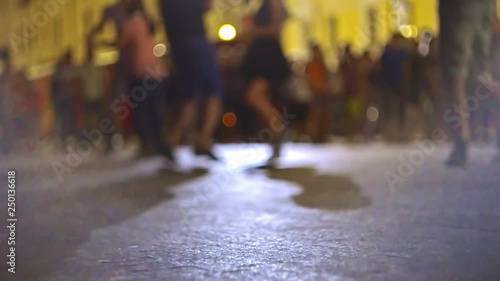 Defocused couples on background dancing salsa in the street photo