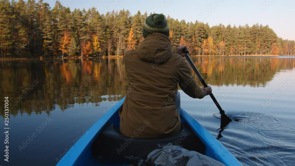 Woman canoeing on lake at sunset Woman canoeing on lake at sunset