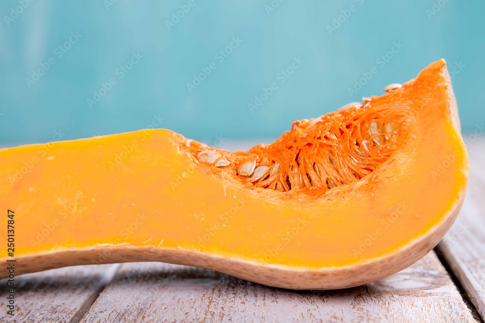 A fresh piece of pumpkin on a wooden background A fresh piece of pumpkin on a wooden background
