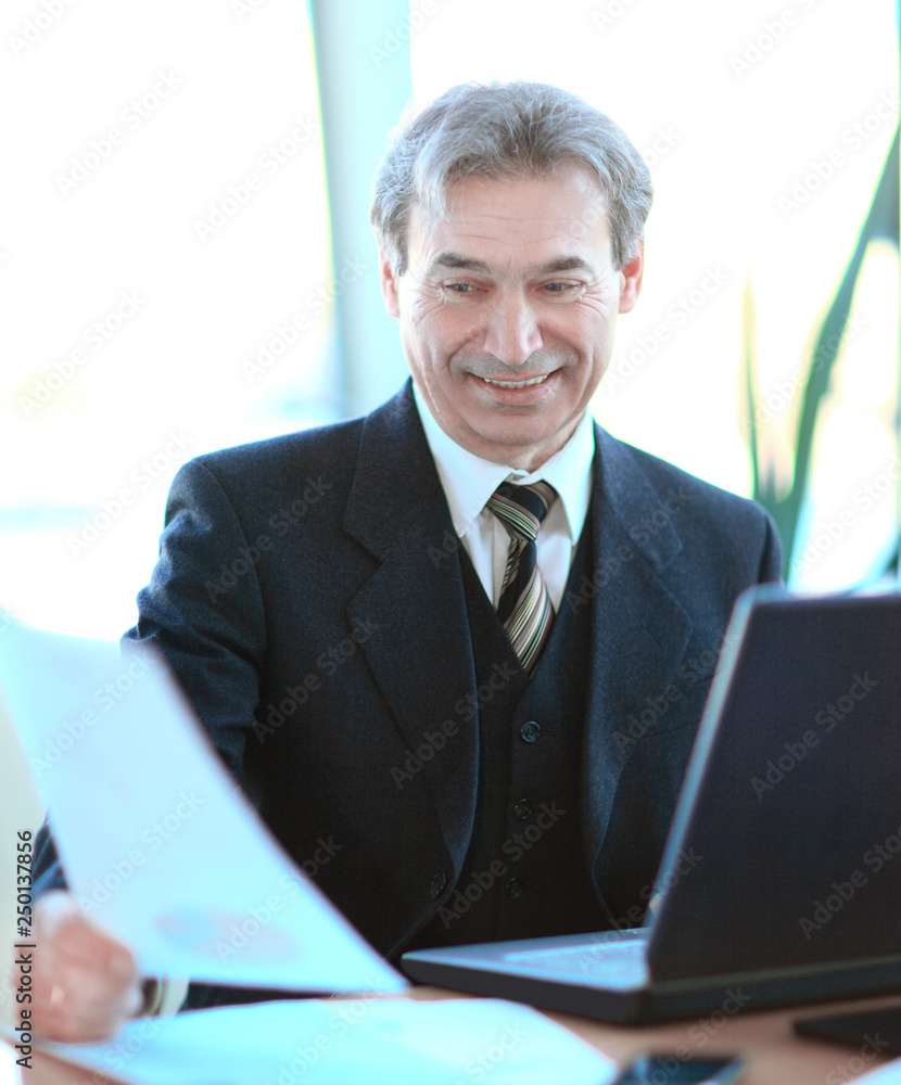 smiling senior businessman sitting at his Desk smiling senior businessman sitting at his Desk