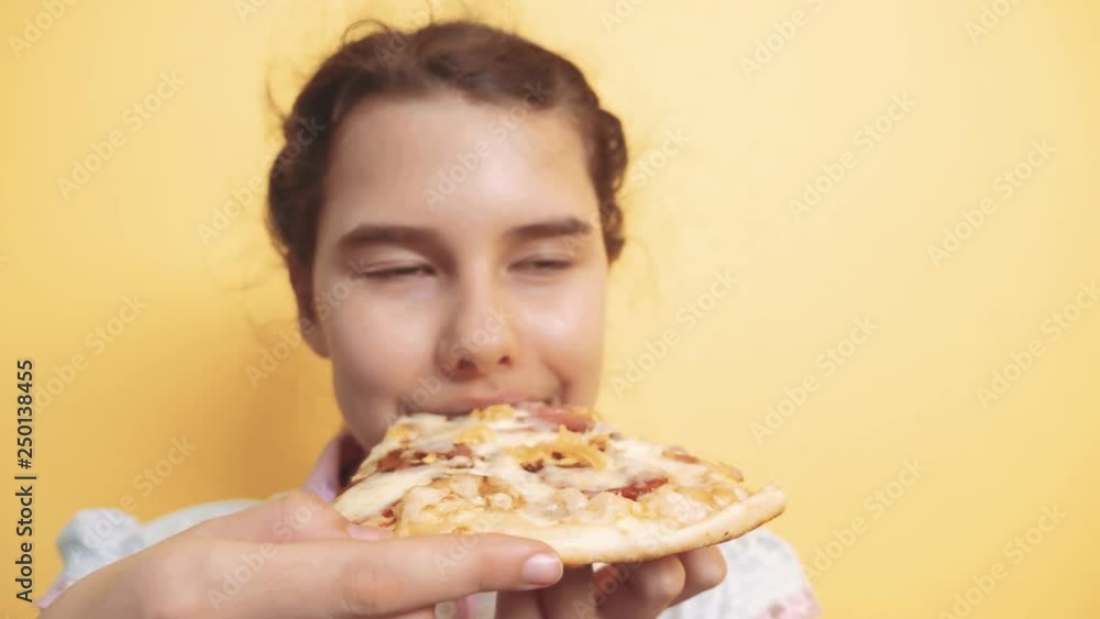 happy little girl eating a slice of pizza concept. teenager child hungry eats a slice of pizza. slow motion video. pizza lifestyle fast food concept happy little girl eating a slice of pizza concept. teenager child hungry eats a slice of pizza. slow motion video. pizza lifestyle fast food concept