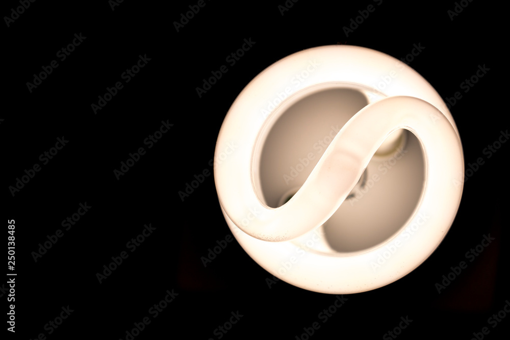Looking up under a lit compact fluorescent lamp. Only the illuminated bulb is visible. Looking up under a lit compact fluorescent lamp. Only the illuminated bulb is visible.
