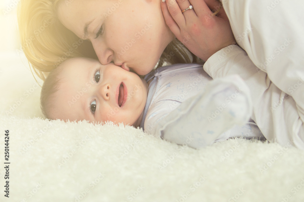 Young infant boy kissing with mother at home Young infant boy kissing with mother at home