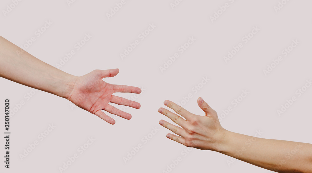 Help and help each other, reaching out for a helping hand. The hand is trying to grab the other hand. View of two hands on a bright gray background. Indifference to harm. Help and help each other, reaching out for a helping hand. The hand is trying to grab the other hand. View of two hands on a bright gray background. Indifference to harm.