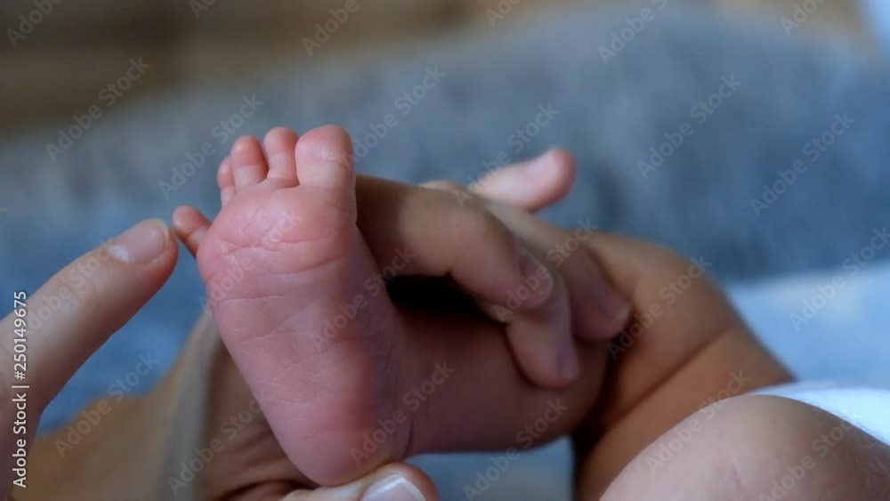 mother strokes her newborn baby's feet mother strokes her newborn baby's feet