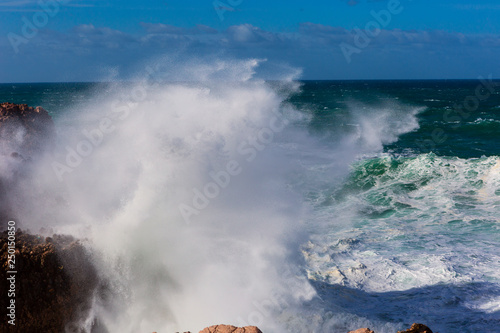 Sea waves hitting rocks cliff at Praia Da Bordeira, Portugal