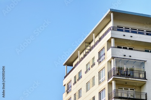 Modern white building with balcony on a blue sky