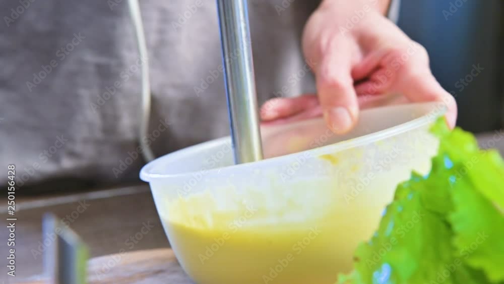 close-up whipping homemade mayonnaise with a blender in a plastic bowl close-up whipping homemade mayonnaise with a blender in a plastic bowl