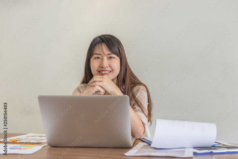Smiling business employee working on laptop in office Smiling business employee working on laptop in office
