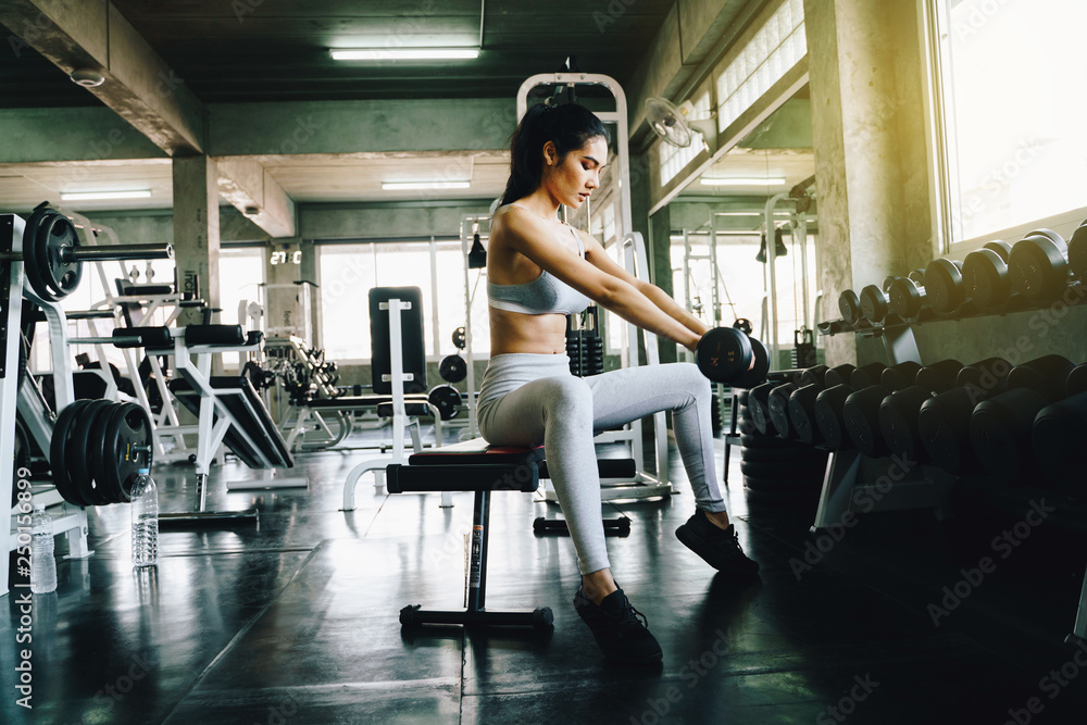 Youn sexy sport women exercise with dumbbell work out in the gym Youn sexy sport women exercise with dumbbell work out in the gym