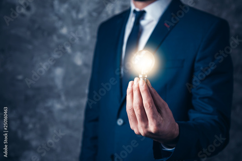 man hand light bulb on dark background