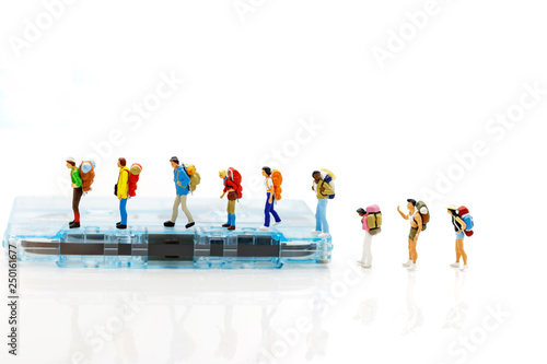 Miniature people: Traveller with backpack walking on the path of tourism. Travel, explore and adventure concept