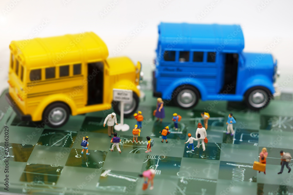 Miniature people: Childrens getting on the schoolbus with teacher.