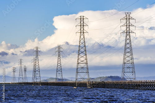 Canvas Print High voltage electricity power lines and transmission towers crossing the ponds
