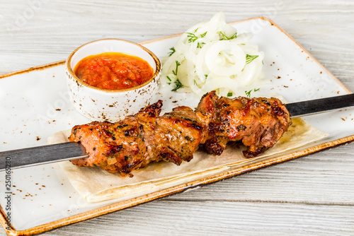 Skewers, onions, pita bread, sauce on a white plate photo