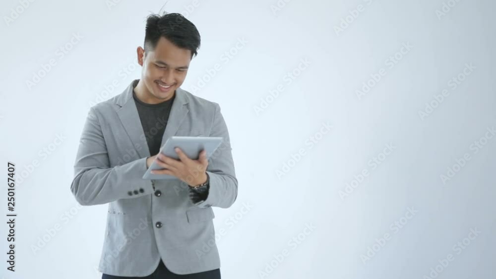 Young business man look so enjoy playing with his tab Young business man look so enjoy playing with his tab