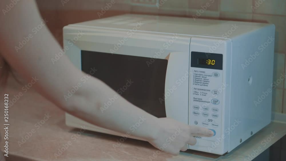 Heated food in the microwave. Female hand puts pies in the microwave in