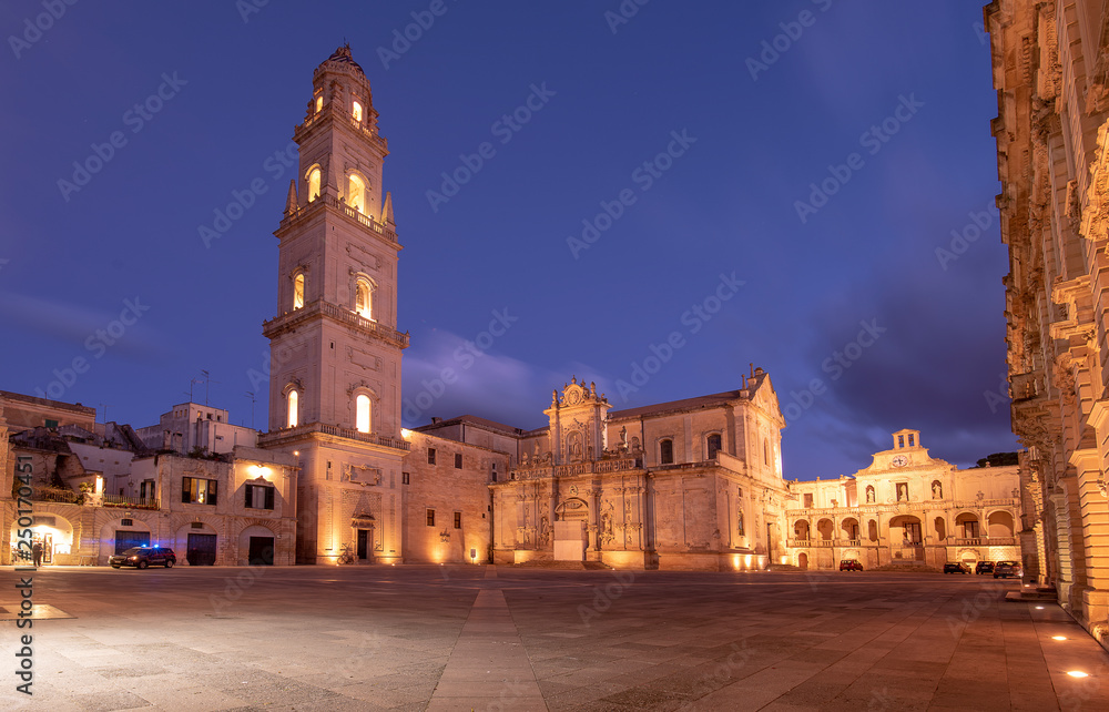 Fototapeta premium Panorama of Piazza del Duomo square , Campanile tower and Virgin Mary Cathedral ( Basilica di Santa Maria Assunta in Cielo ) , Caritas Diocesana in Lecce - Puglia, Italy. Baroque city of Apulia night