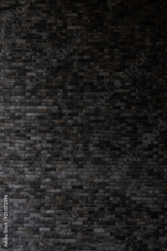 Close up dark grey brick wall background.