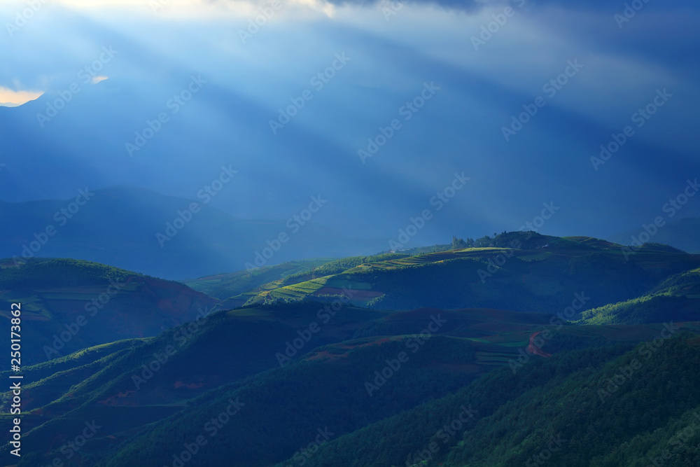 Beautiful light beam in morning with red soil and village on mountain valleys at Hongtudi,Dongchuan, Yunnan,Kunming of China