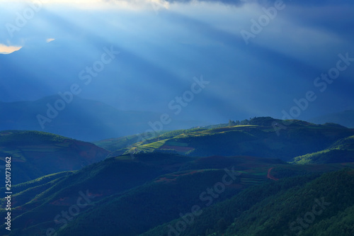 Beautiful light beam in morning with red soil and village on mountain valleys at Hongtudi,Dongchuan, Yunnan,Kunming of China