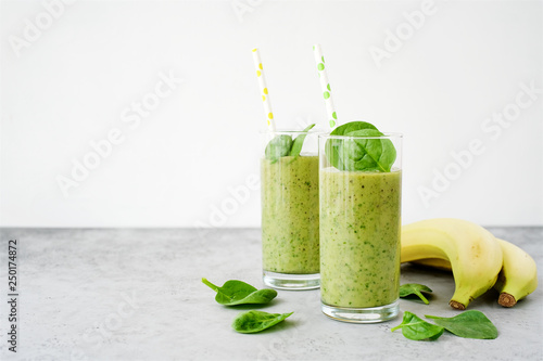 Green smoothie with banana and spinach or other green vegetables and fruits. Gray light background