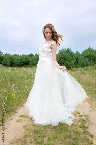 Young attractive bride in white stylish wedding dress outdoors, make up and hairstyle