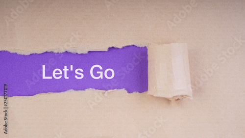 LET'S GO text on brown envelope and torn paper. Concept Image