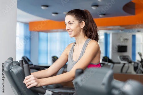 Young smiling woman on a cardio in the gym © Анна Демидова