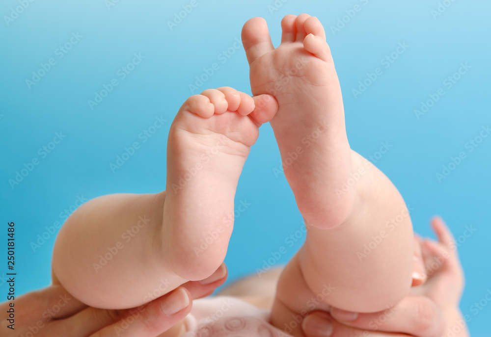 Feminine palm holding a baby foot Feminine palm holding a baby foot