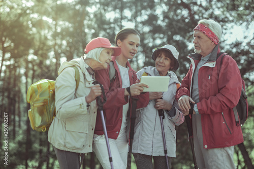 Group of tourists using interactive map for hiking