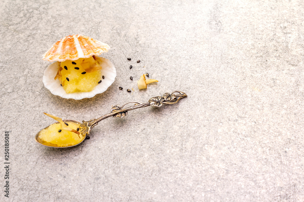 Capelin roe in seashells. Black sesame seeds with bonito flakes. Lightly salted caviar snack in silver spoon on a stone background Capelin roe in seashells. Black sesame seeds with bonito flakes. Lightly salted caviar snack in silver spoon on a stone background