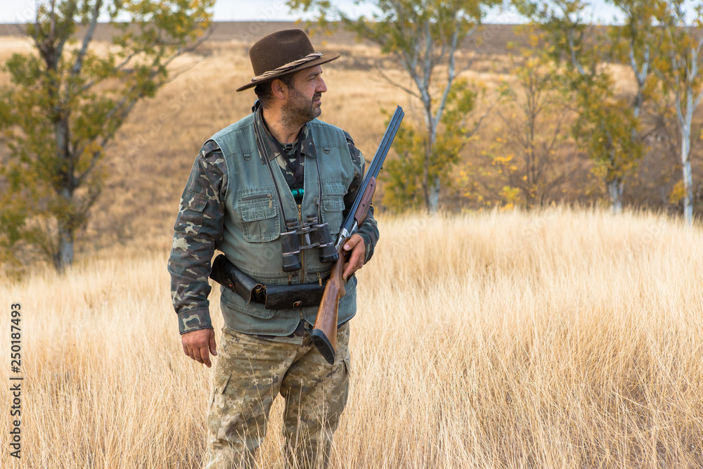 Hunter with a hat and a gun in search of prey in the steppe Hunter with a hat and a gun in search of prey in the steppe