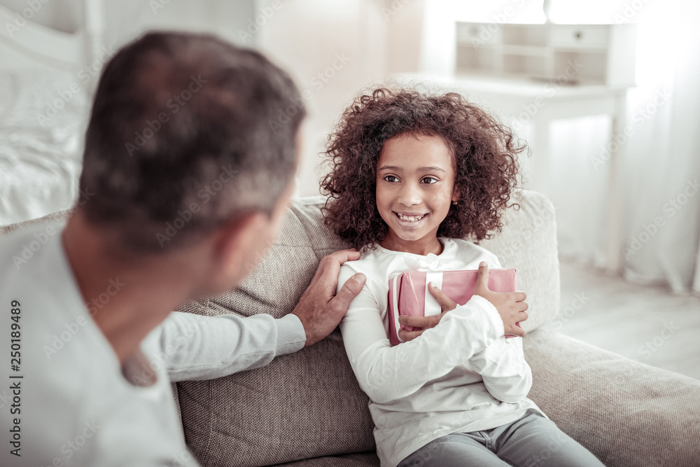 Smiling happy girl looking at her careful father Smiling happy girl looking at her careful father