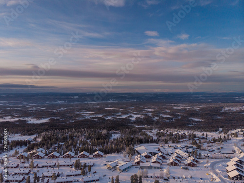 Panorama aerial view of Idre Fjäll cabins during sunrise a clear winter day in Sweden with one of the slopes in the photo. 