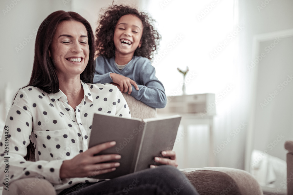 Beautiful nice mother reading a book together with a daughter Beautiful nice mother reading a book together with a daughter