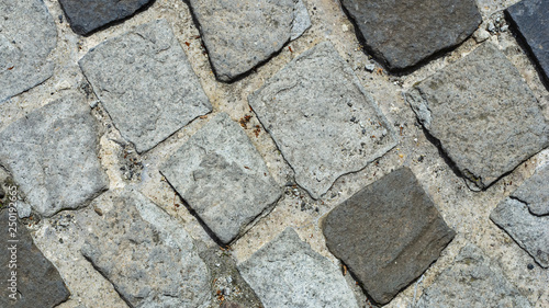 Cobble stones in concrete on a path, background texture macro, selective focus