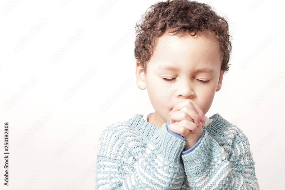 boy praying to God with hands held together boy praying to God with hands held together