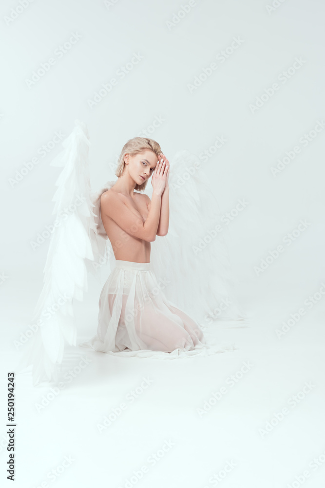 beautiful woman with angel wings looking at camera and posing isolated on white beautiful woman with angel wings looking at camera and posing isolated on white