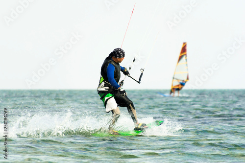 Kitesurfing and windsurfing action photos. Man rides a kite on windsurfer background. Selected focus