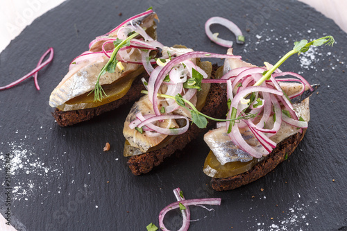 Herring bruschetta on plate. Traditional cuisine. Close-up