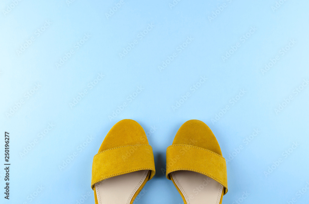 Two sandals mustard color blue background. Stock Photo | Adobe Stock