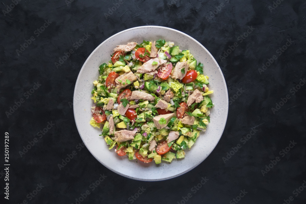 Avocado Tuna Salad in a plate on black table. Avocado Tuna Salad in a plate on black table.