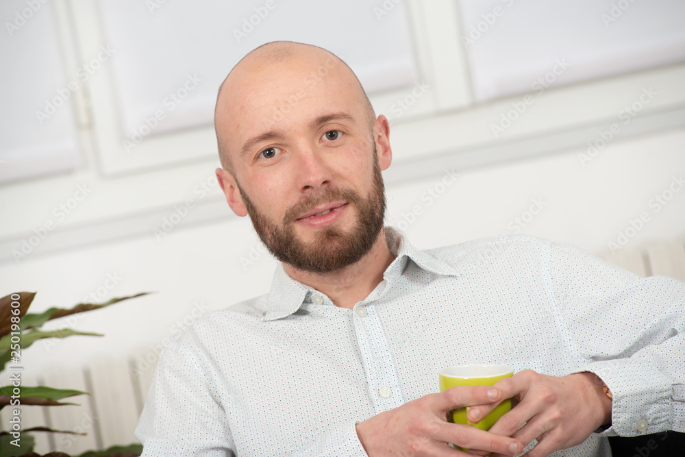 young man with a beard drinking cup of coffee young man with a beard drinking cup of coffee