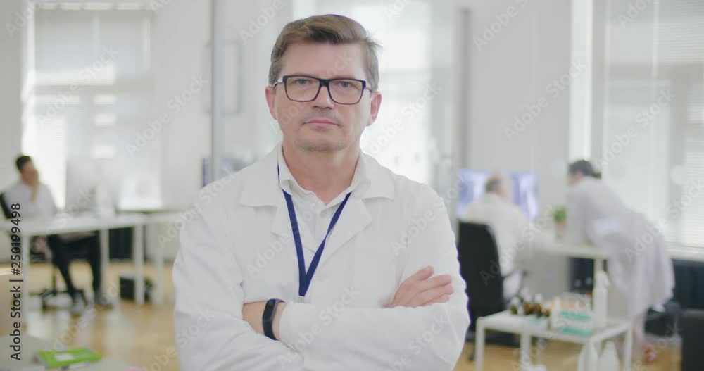 Male doctor oncologist looking at camera and standing with crossed arms Male doctor oncologist looking at camera and standing with crossed arms