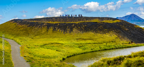 Tourists at the top of pseudo craters aka volcanic near Skutustadir and lake Myvatn on Iceland, summer time