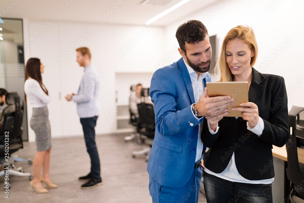 Businesspeople discussing while using digital tablet in office Businesspeople discussing while using digital tablet in office