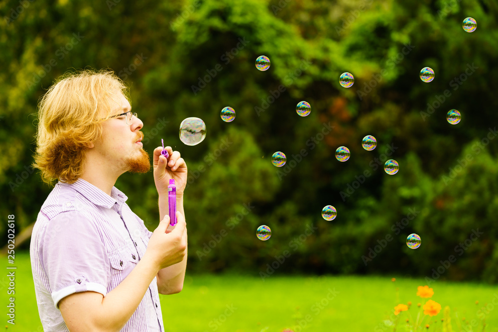 Man blowing soap bubbles outdoor Man blowing soap bubbles outdoor